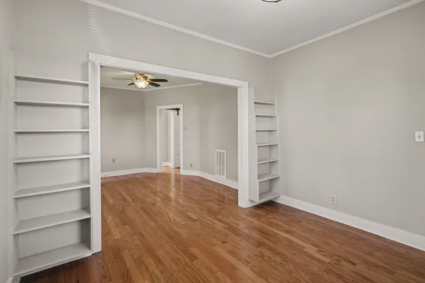 a view of an empty room with a closet and wooden floor
