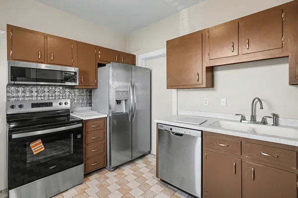 a kitchen with stainless steel appliances granite countertop a stove a refrigerator and a sink