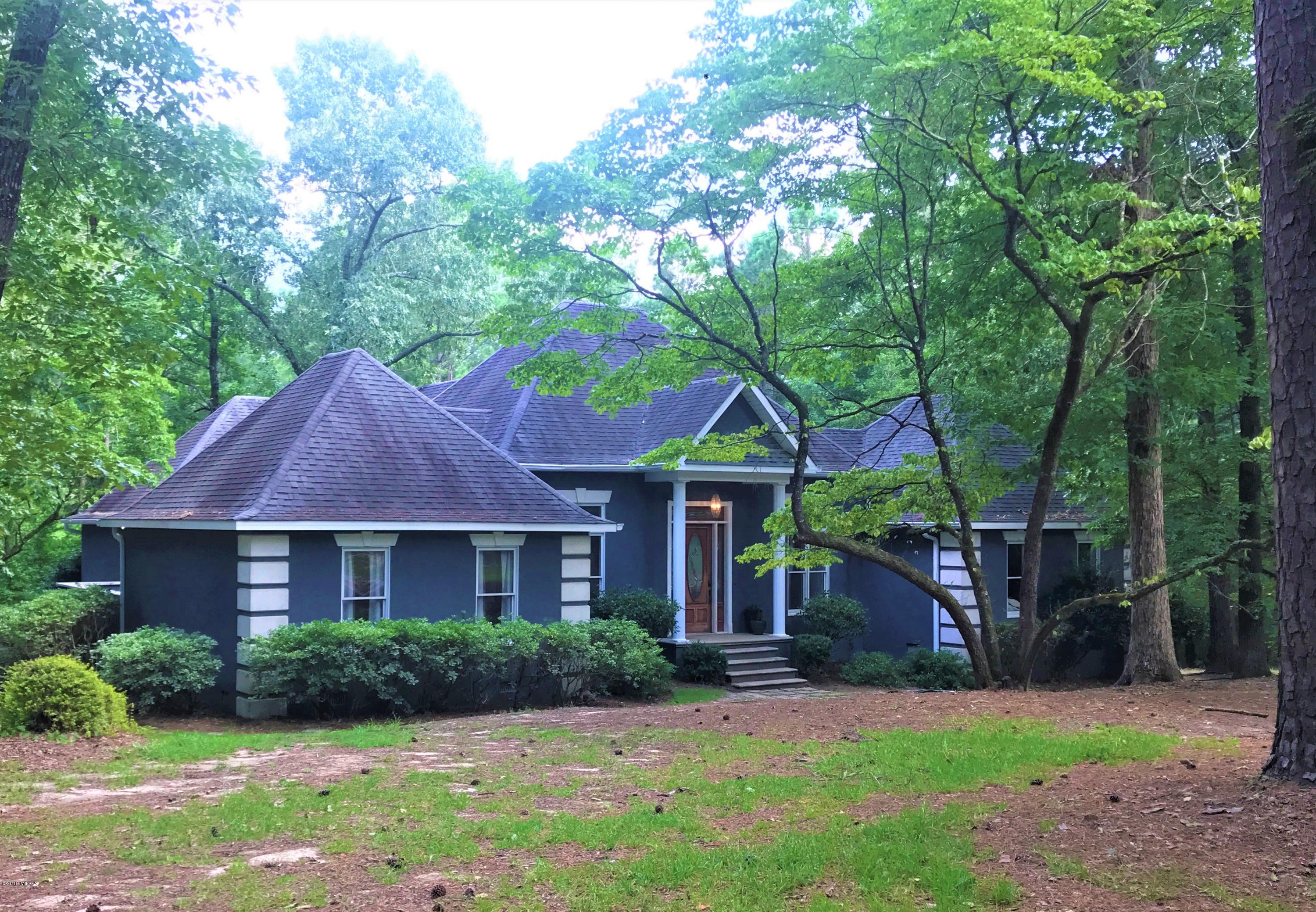 a front view of a house with a yard and trees