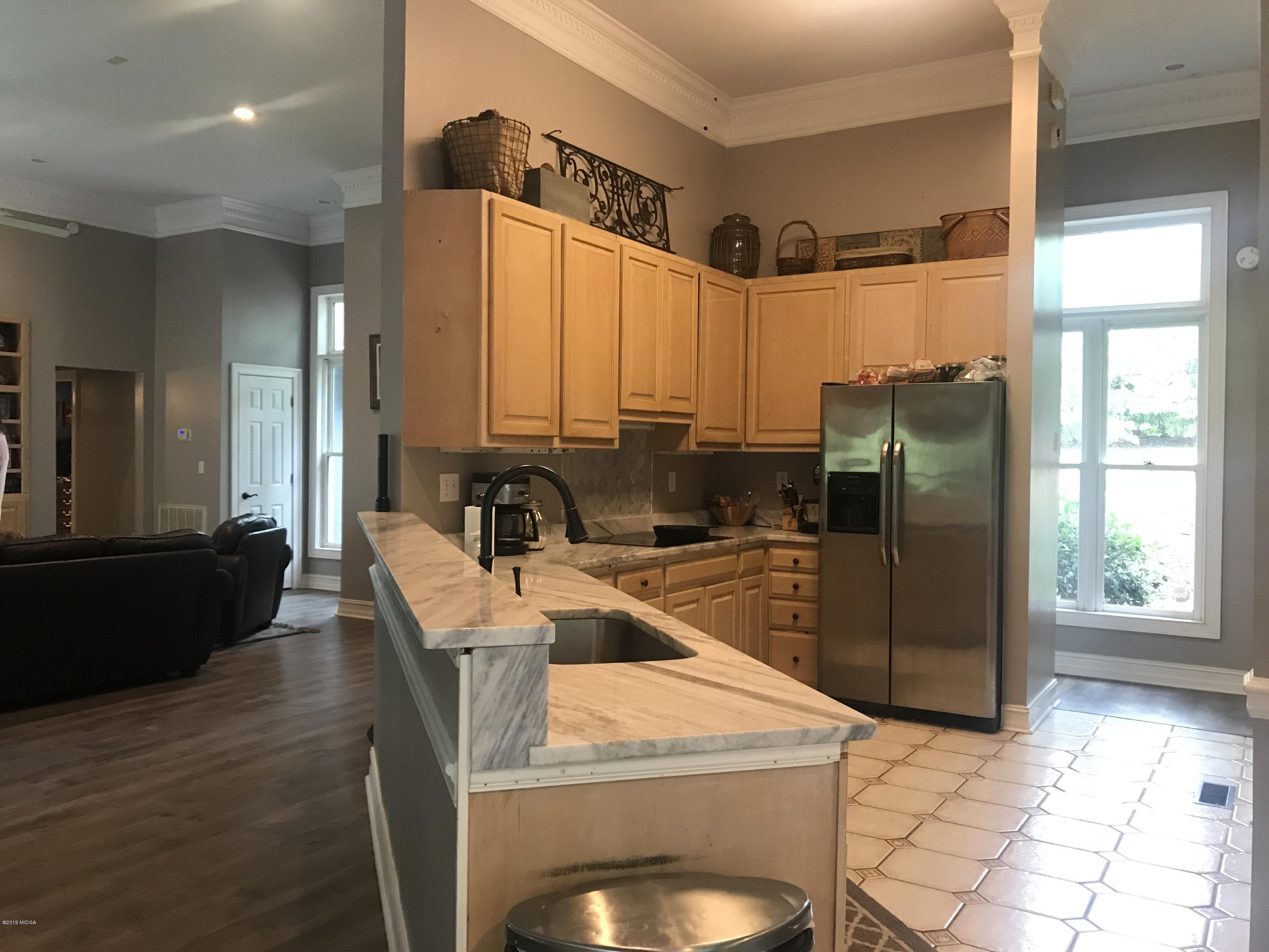 1569 Johnson Road Macon, GA 31220 - Photo 7 of 28 a kitchen with stainless steel appliances granite countertop a refrigerator a stove and a sink with wooden floor
