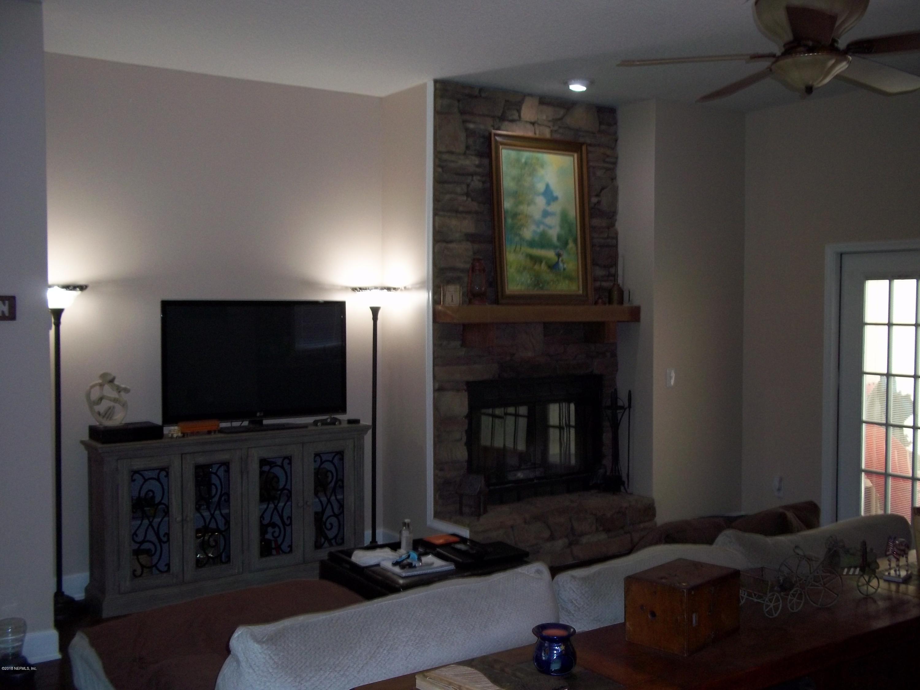 5579 Long Branch Road Jacksonville, FL 32234 - Photo 16 of 54 a living room with fireplace furniture and a flat screen tv
