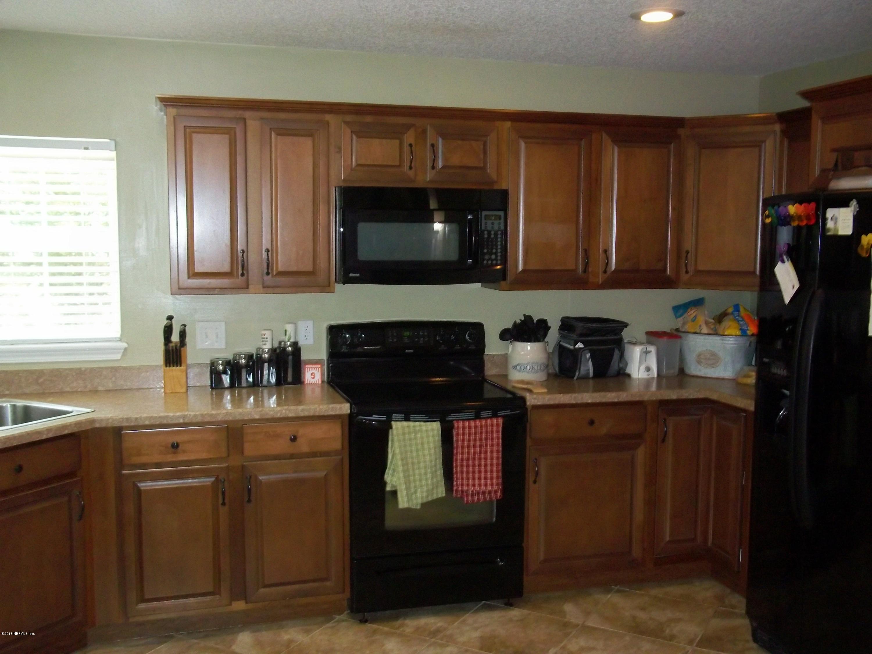 5579 Long Branch Road Jacksonville, FL 32234 - Photo 22 of 54 a kitchen with stainless steel appliances granite countertop a stove a sink and a microwave