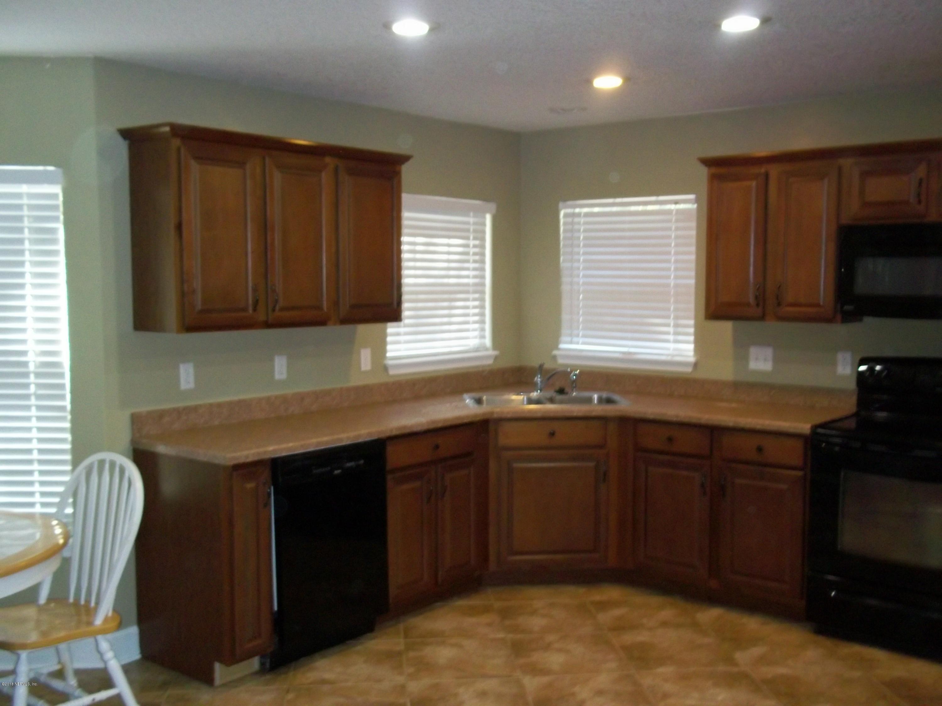 5579 Long Branch Road Jacksonville, FL 32234 - Photo 37 of 54 a kitchen with stainless steel appliances granite countertop wooden cabinets a stove top oven a sink and dishwasher