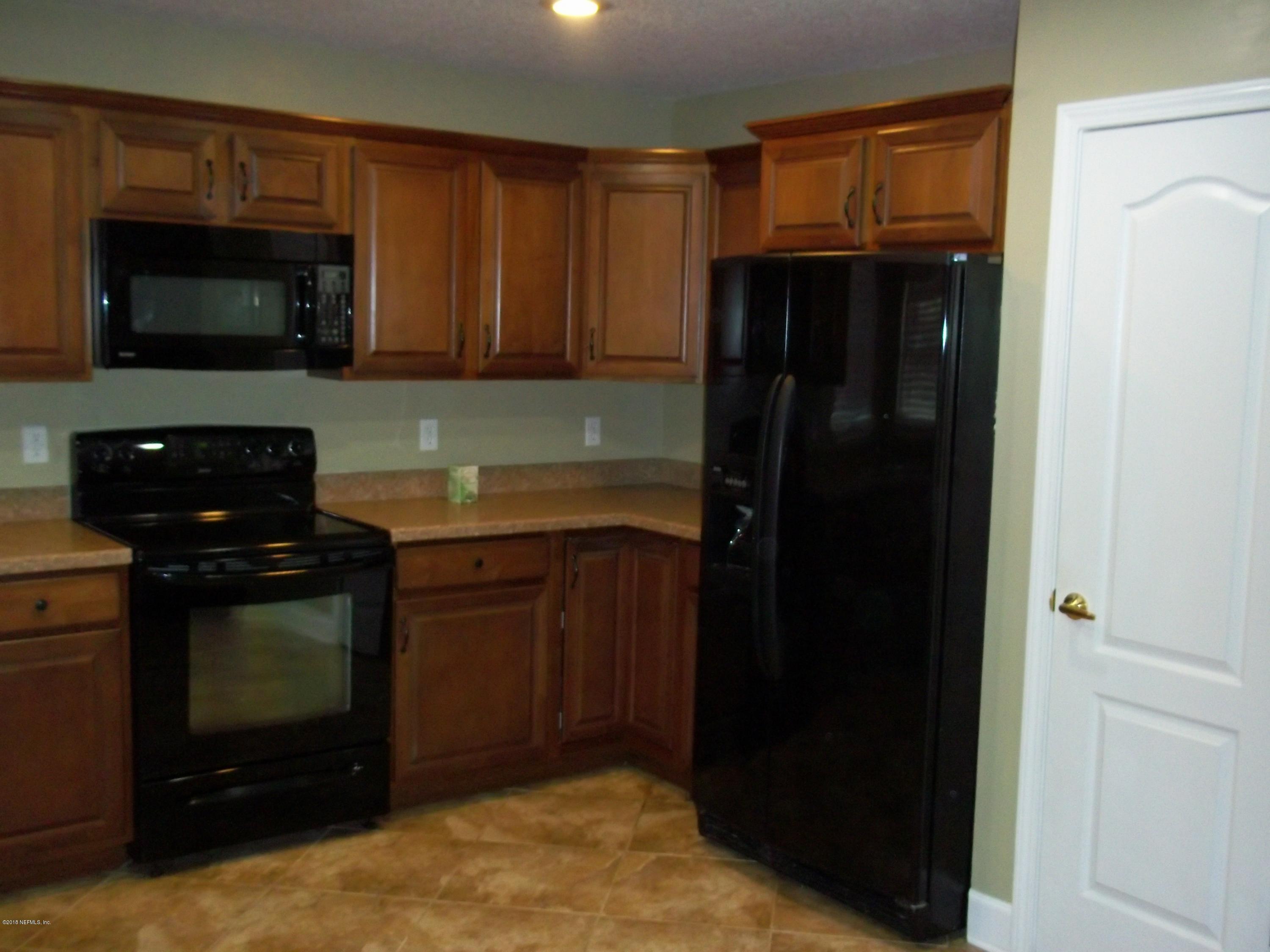 5579 Long Branch Road Jacksonville, FL 32234 - Photo 38 of 54 a kitchen with granite countertop white cabinets and stainless steel appliances