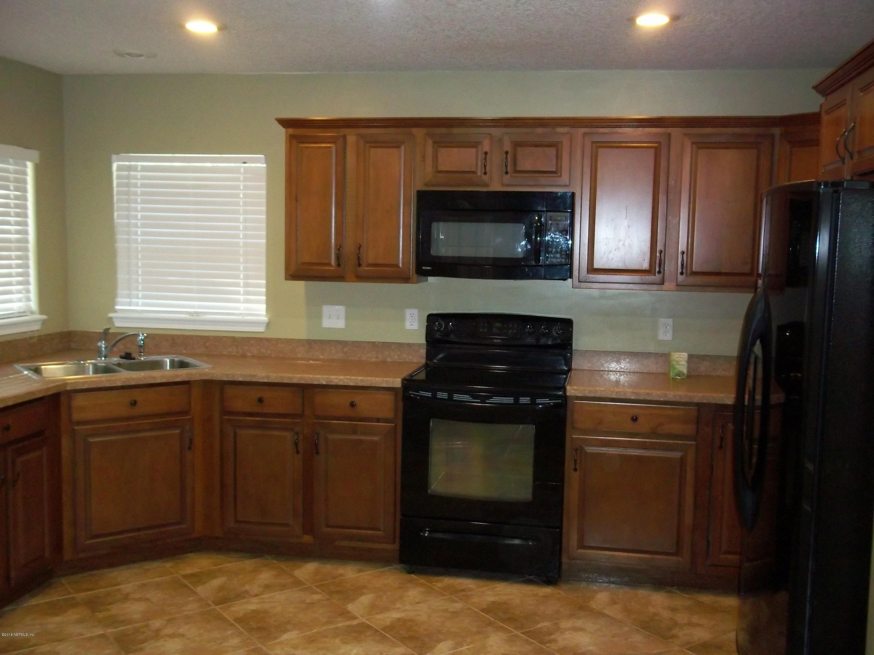 5579 Long Branch Road Jacksonville, FL 32234 - Photo 39 of 54 a kitchen with stainless steel appliances granite countertop a stove microwave and refrigerator