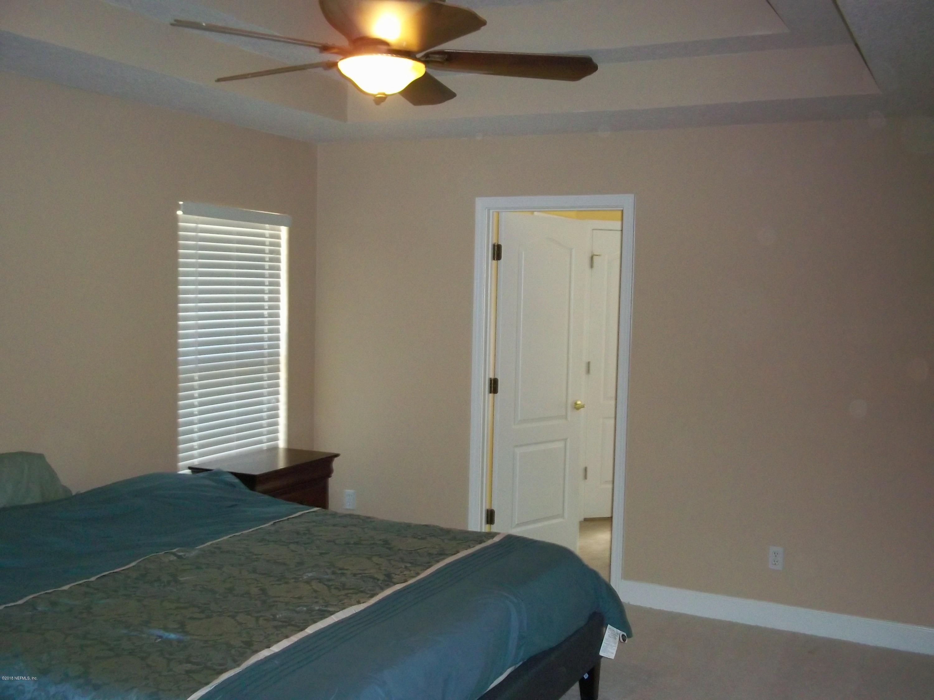 5579 Long Branch Road Jacksonville, FL 32234 - Photo 47 of 54 a bedroom with a bed and a chandelier