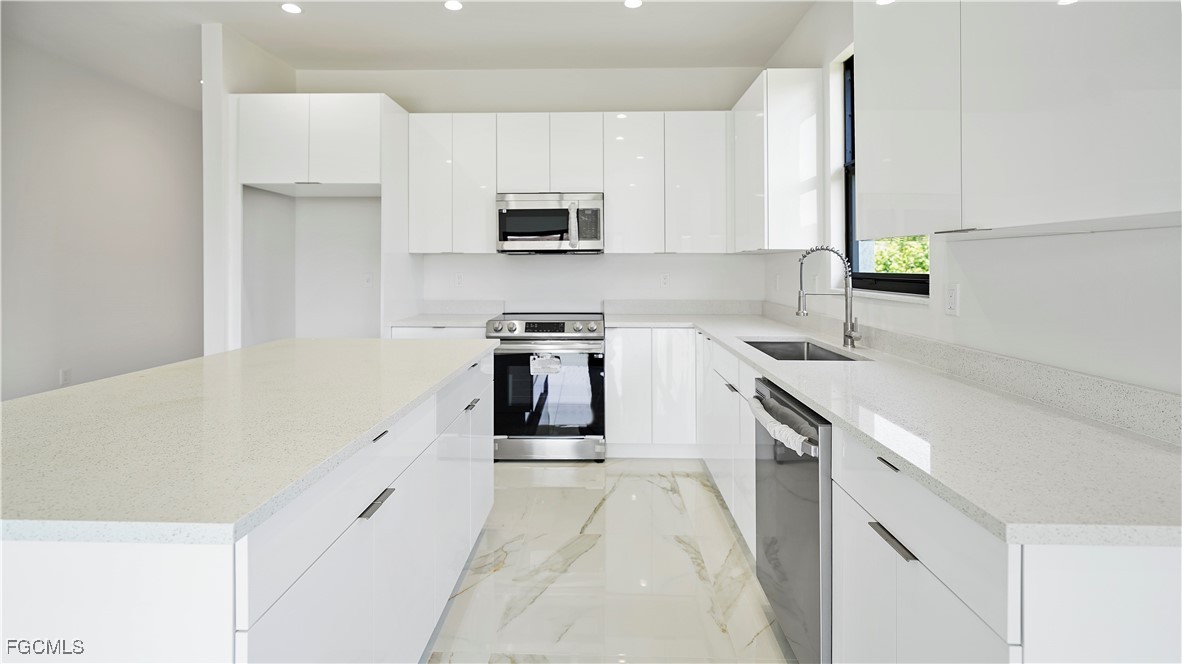 123 Ichabod Avenue Lehigh Acres, FL 33973 - Photo 17 of 42 a kitchen with a sink stove and microwave