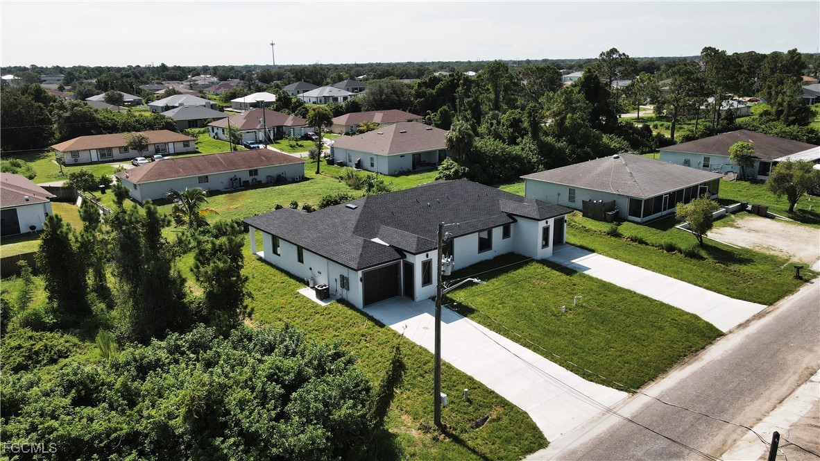 123 Ichabod Avenue Lehigh Acres, FL 33973 - Photo 4 of 42 a aerial view of a house with a garden and trees