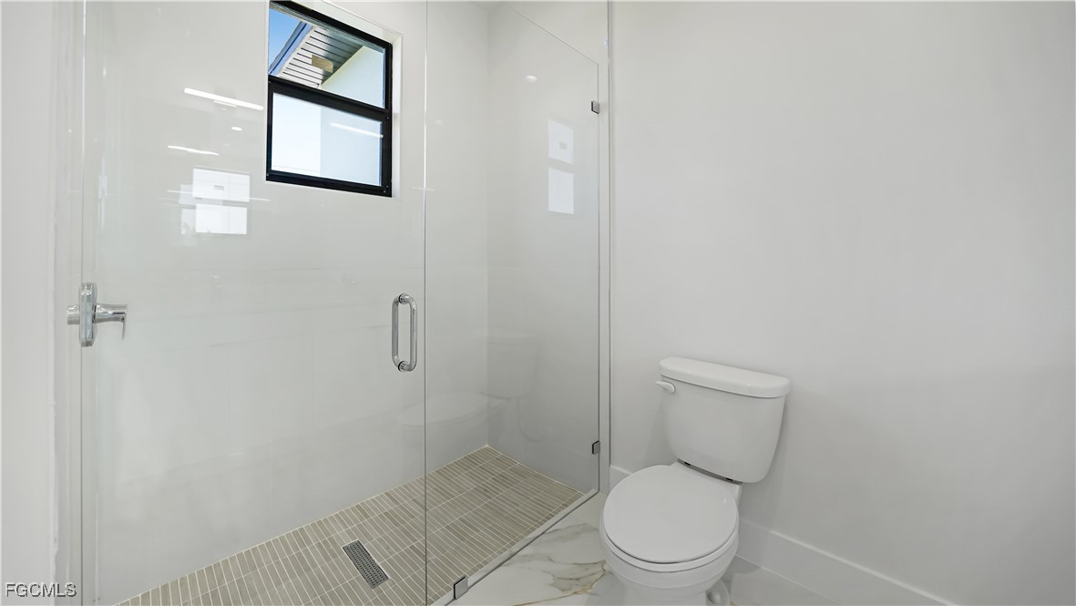 123 Ichabod Avenue Lehigh Acres, FL 33973 - Photo 42 of 42 a white toilet sitting next to a shower