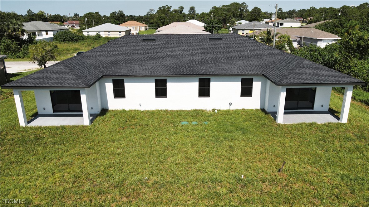 123 Ichabod Avenue Lehigh Acres, FL 33973 - Photo 10 of 42 a front view of a house with a yard and garage