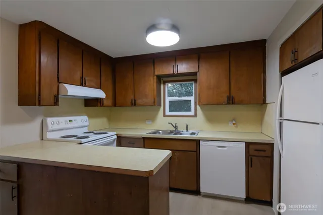 a kitchen with a sink a stove and cabinets