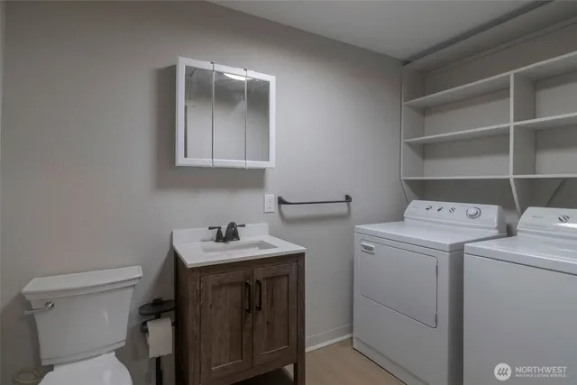 a bathroom with a sink toilet vanity and tub