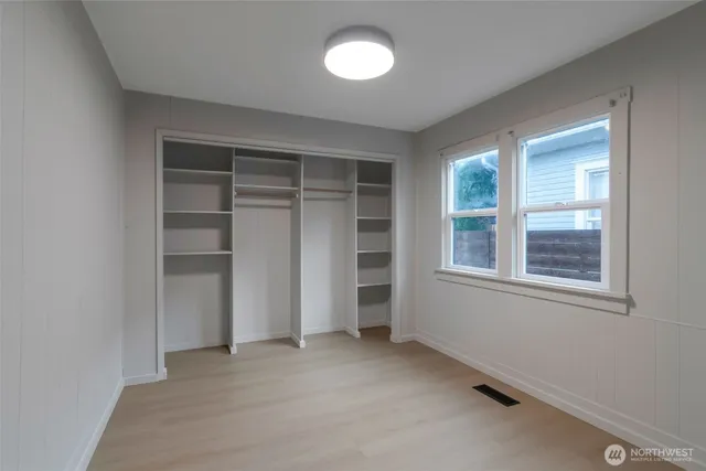 an empty room with a window and closet