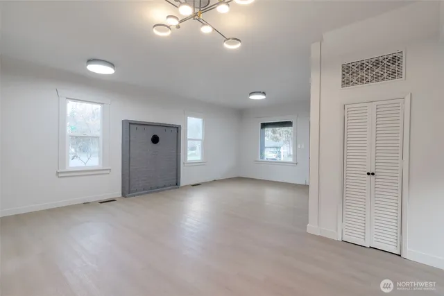 an empty room with windows and closet