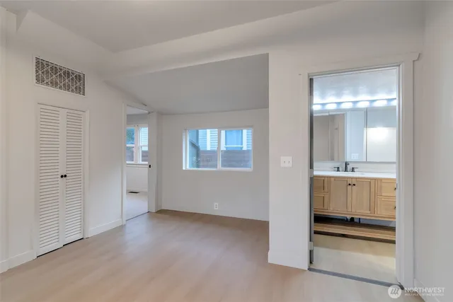 a view of a hallway with bathroom and wooden floor