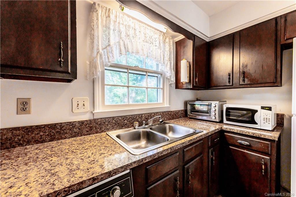 7518 Riding Trail Road Charlotte, NC 28212 - Photo 6 of 36 a kitchen with a sink stove and microwave