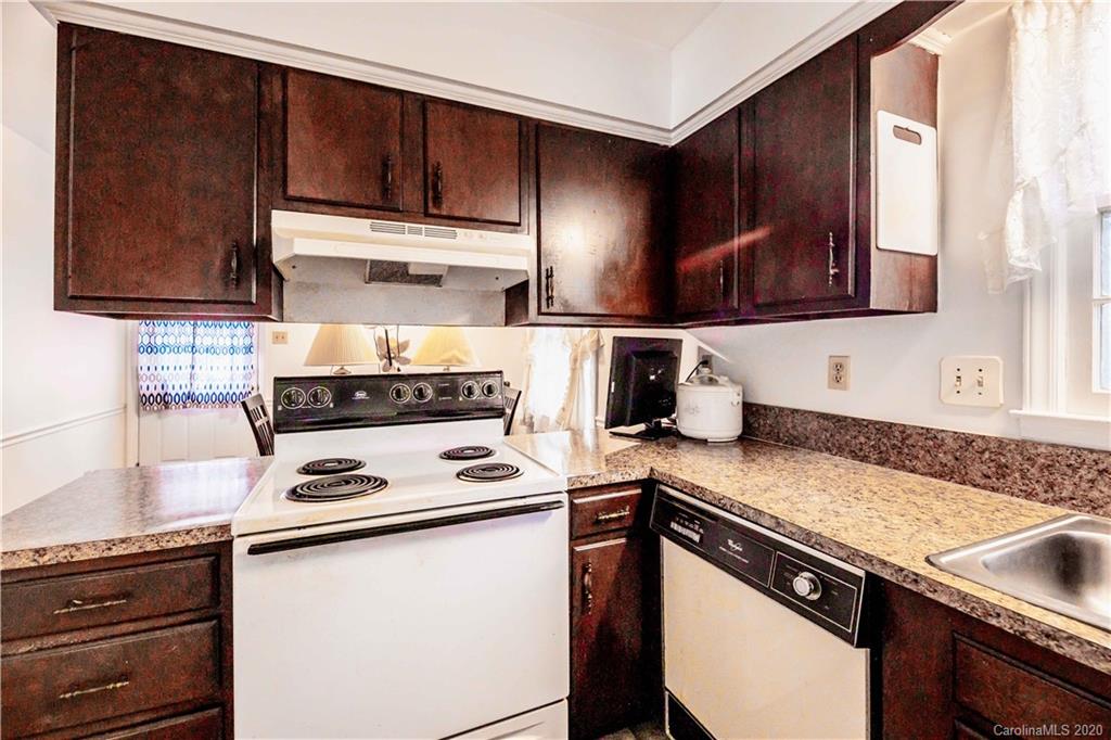 7518 Riding Trail Road Charlotte, NC 28212 - Photo 7 of 36 a kitchen with granite countertop a stove sink and cabinets