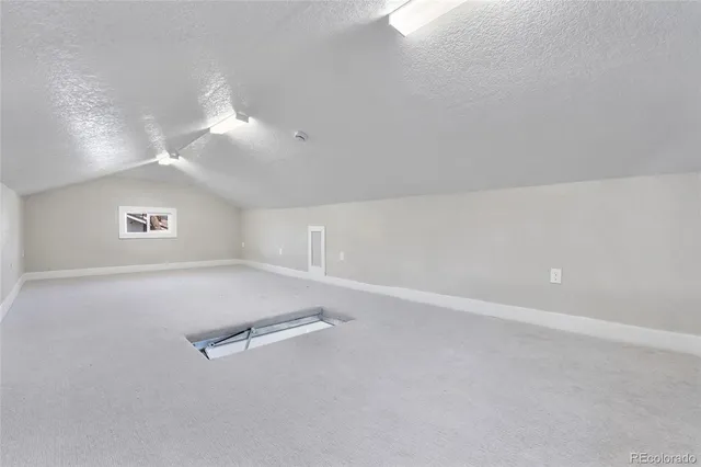 an empty room with windows and ceiling fan