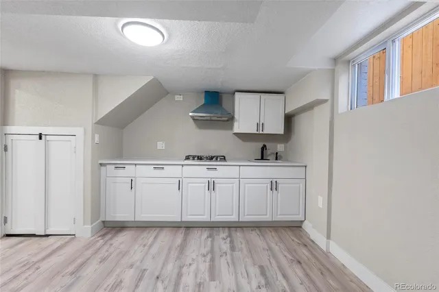 a kitchen with cabinets stove and a sink