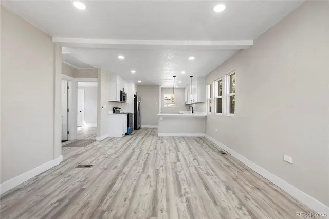 a view of a kitchen with wooden floor and windows