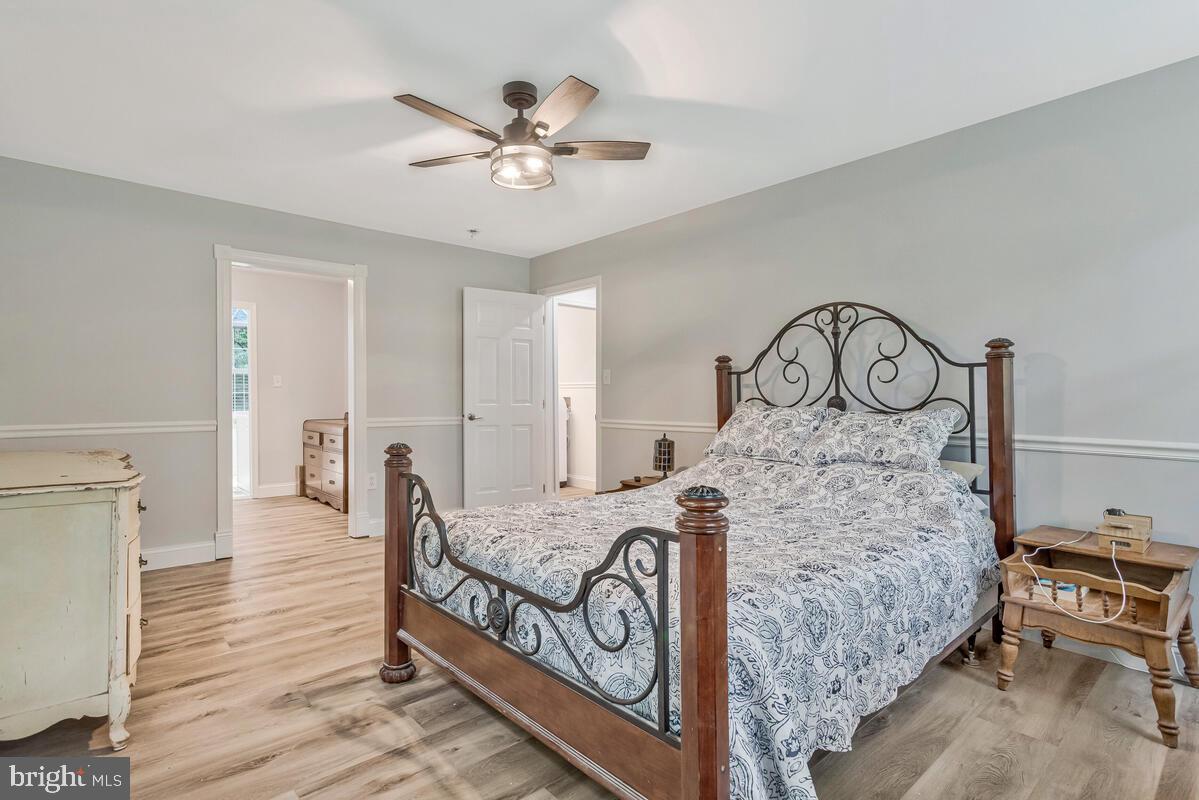 5963 Hillside Road St. Leonard, MD 20685 - Photo 28 of 54 a bed room with a bed and a chandelier