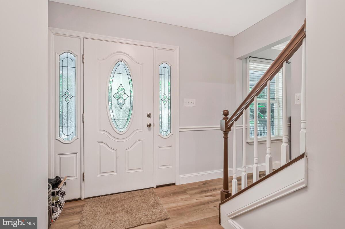 5963 Hillside Road St. Leonard, MD 20685 - Photo 8 of 54 a view of a entryway with wooden floor and mirror