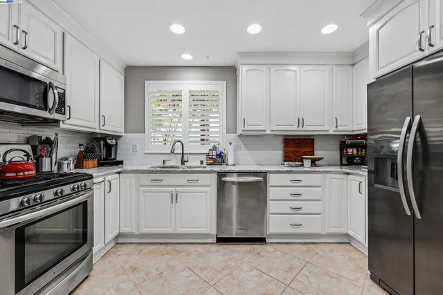 a kitchen with stainless steel appliances granite countertop a stove a refrigerator and a microwave