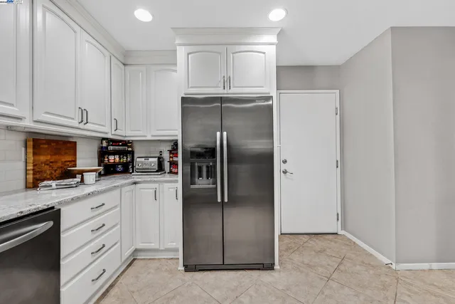 a kitchen with cabinets stainless steel appliances and a refrigerator