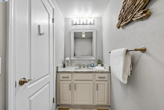a bathroom with a sink vanity and mirror