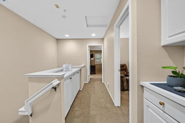 a view of a kitchen with refrigerator and white cabinets