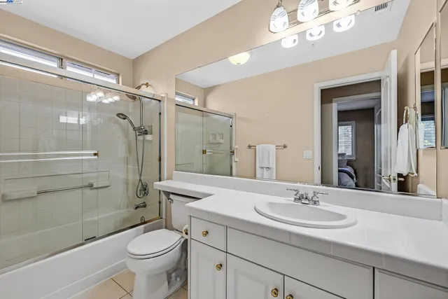 a bathroom with a sink a toilet a mirror and shower