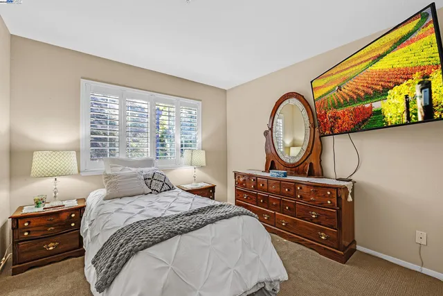 a bedroom with a bed a mirror and a window