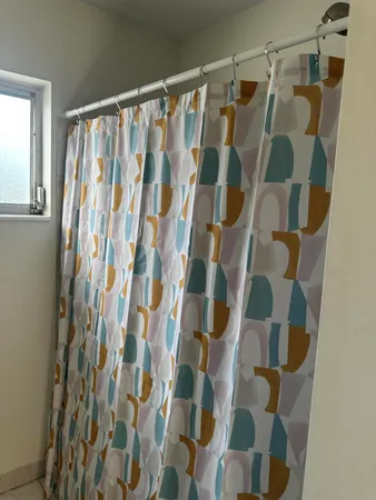 a bathroom with a shower curtain and a curtain
