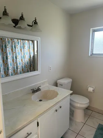 a bathroom with a toilet sink and mirror