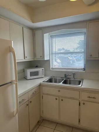 a kitchen with white cabinets and white appliances