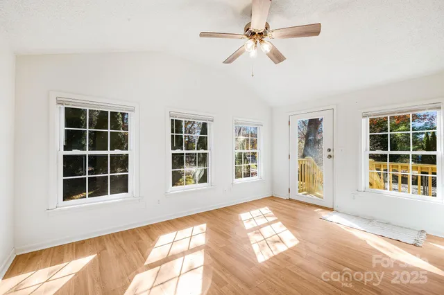 a view of an empty room with a fireplace and a window