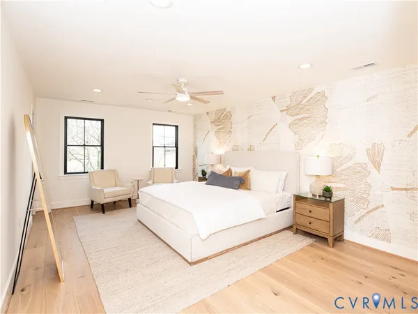 a bedroom with a large bed and a chandelier