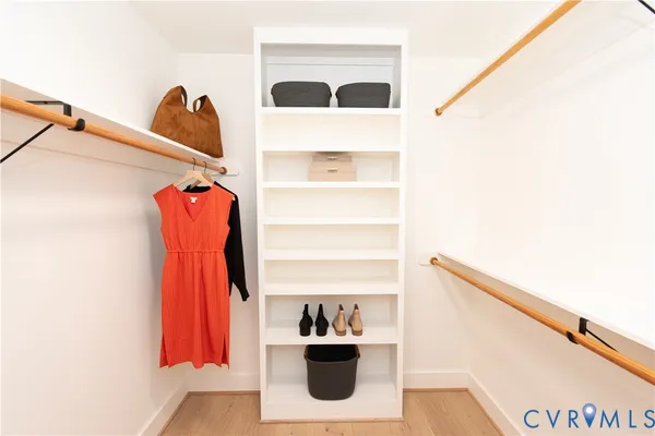 a view of walk in closet with clothes and shoes