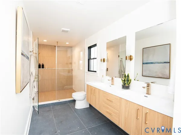 a bathroom with a double vanity sink toilet mirror and bathtub