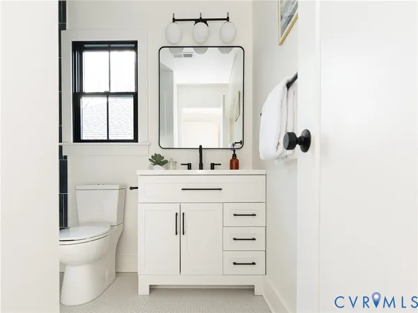 a bathroom with a sink a toilet and a mirror