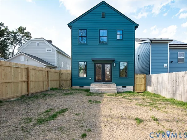 a view of a house with a yard and wooden fence