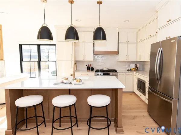 a kitchen with stainless steel appliances granite countertop a sink a stove and chairs