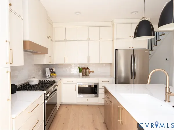 a kitchen with stainless steel appliances a refrigerator sink and cabinets