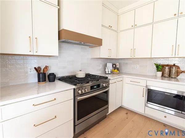 a kitchen with stainless steel appliances granite countertop a sink a stove and cabinets