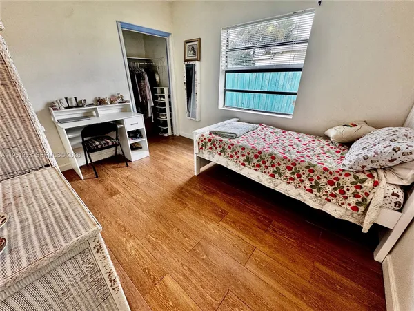 a bedroom with a bed closet and a window