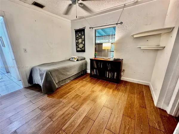 a bedroom with a bed and wooden floor