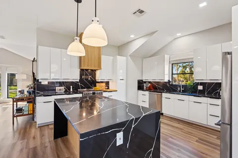 a kitchen with counter space dining table and stainless steel appliances