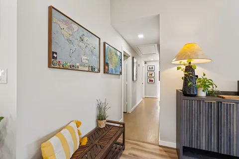 a view of a hallway with furniture and wooden floor