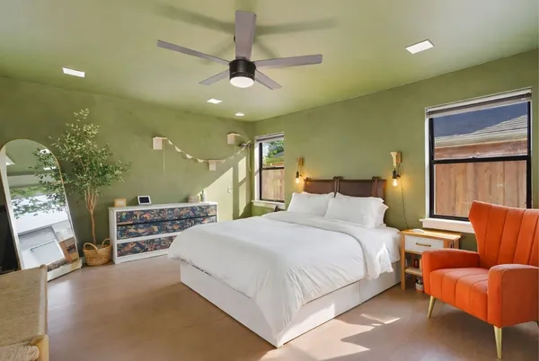 a bedroom with a bed and furniture with a chandelier