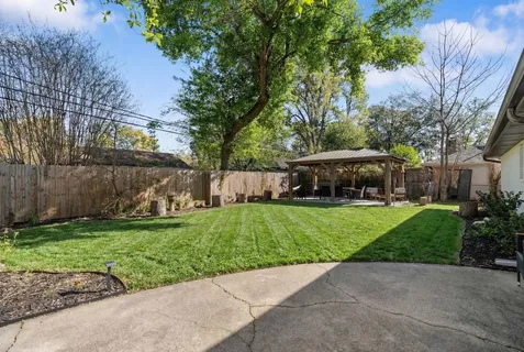 a view of a yard with a house and a street